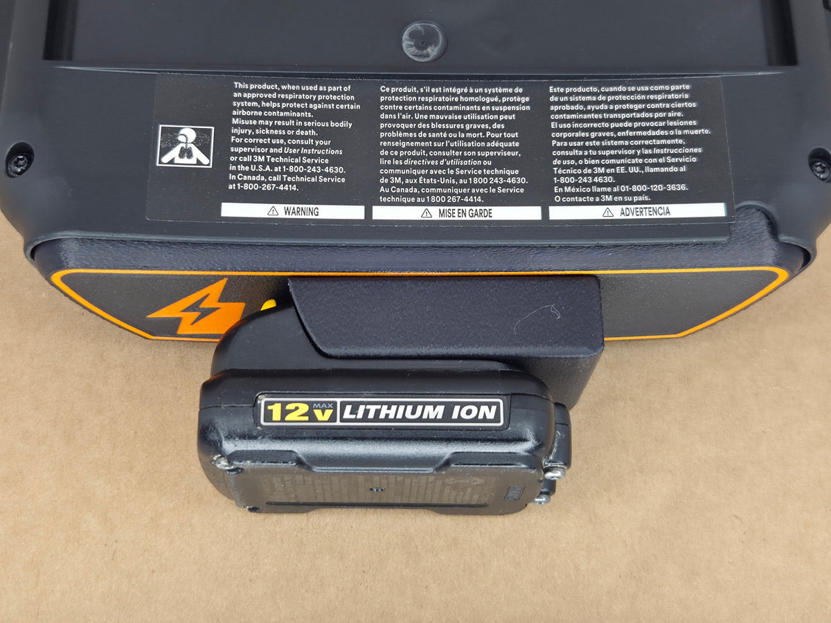 DeWalt 12V MAX Adflo adapter - underside warning-label block with engaged 12V pack - close-up
