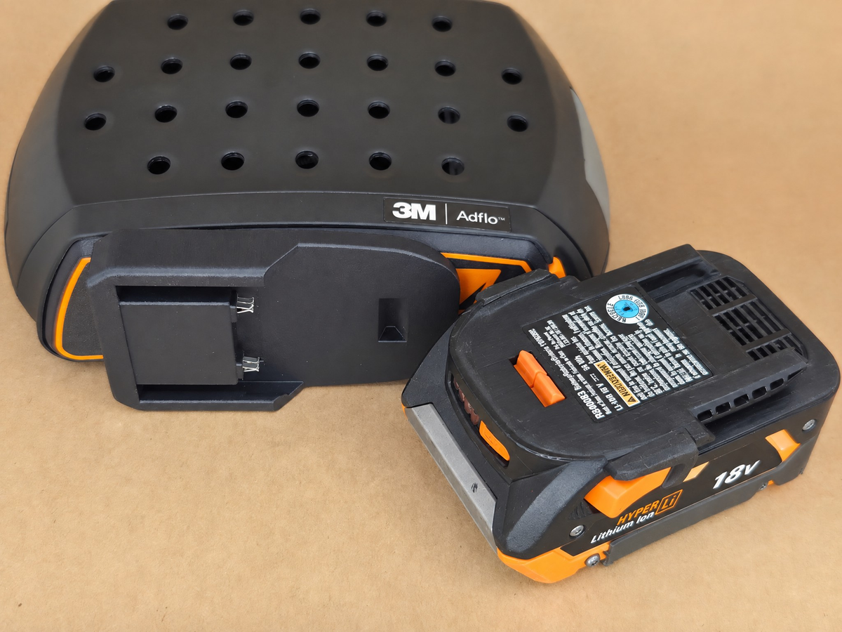 RIDGID AEG 18V Adflo adapter - compact AEG 18V pack angled against the battery slot - fit view